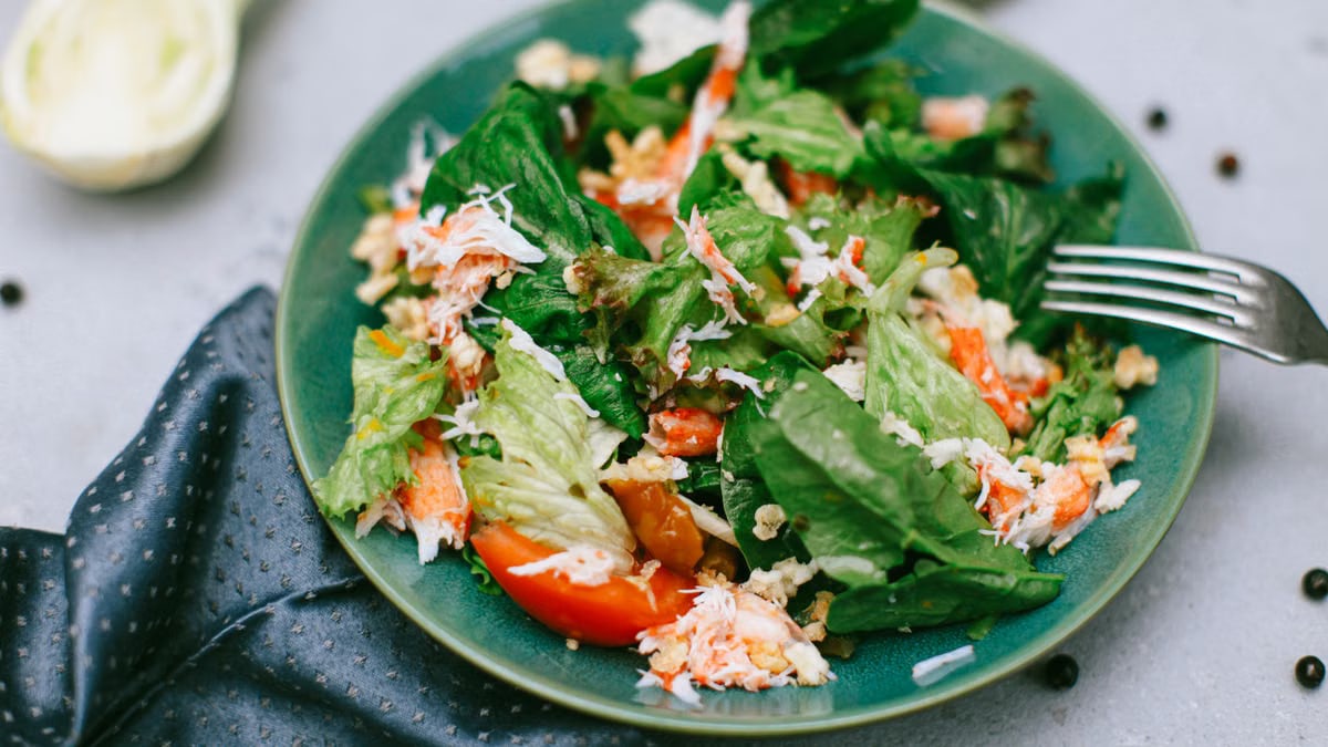 A vibrant green salad featuring mixed vegetables on a blue plate.